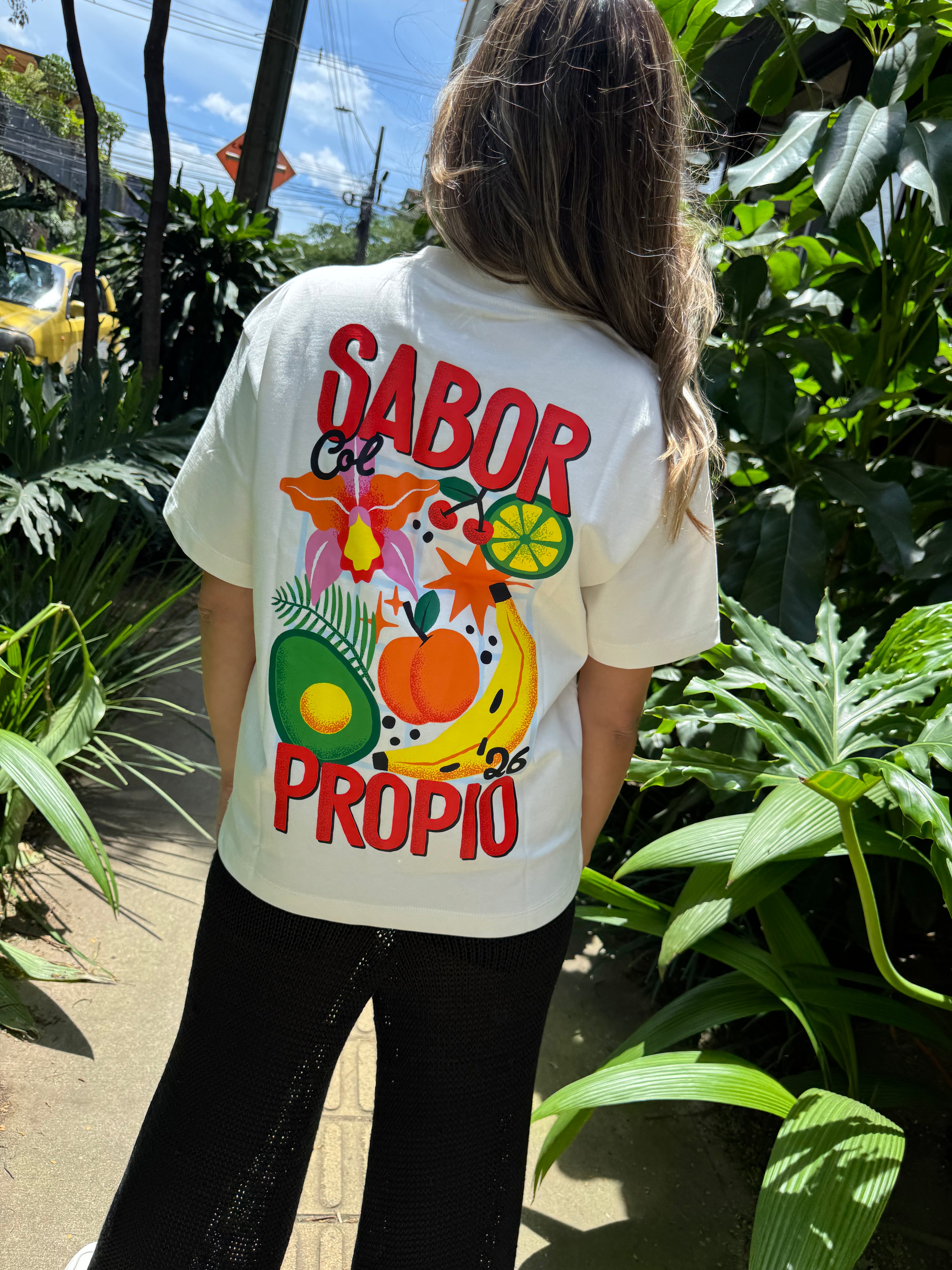 Camiseta Sabor Propio blanca con ilustración de frutas tropicales colombianas