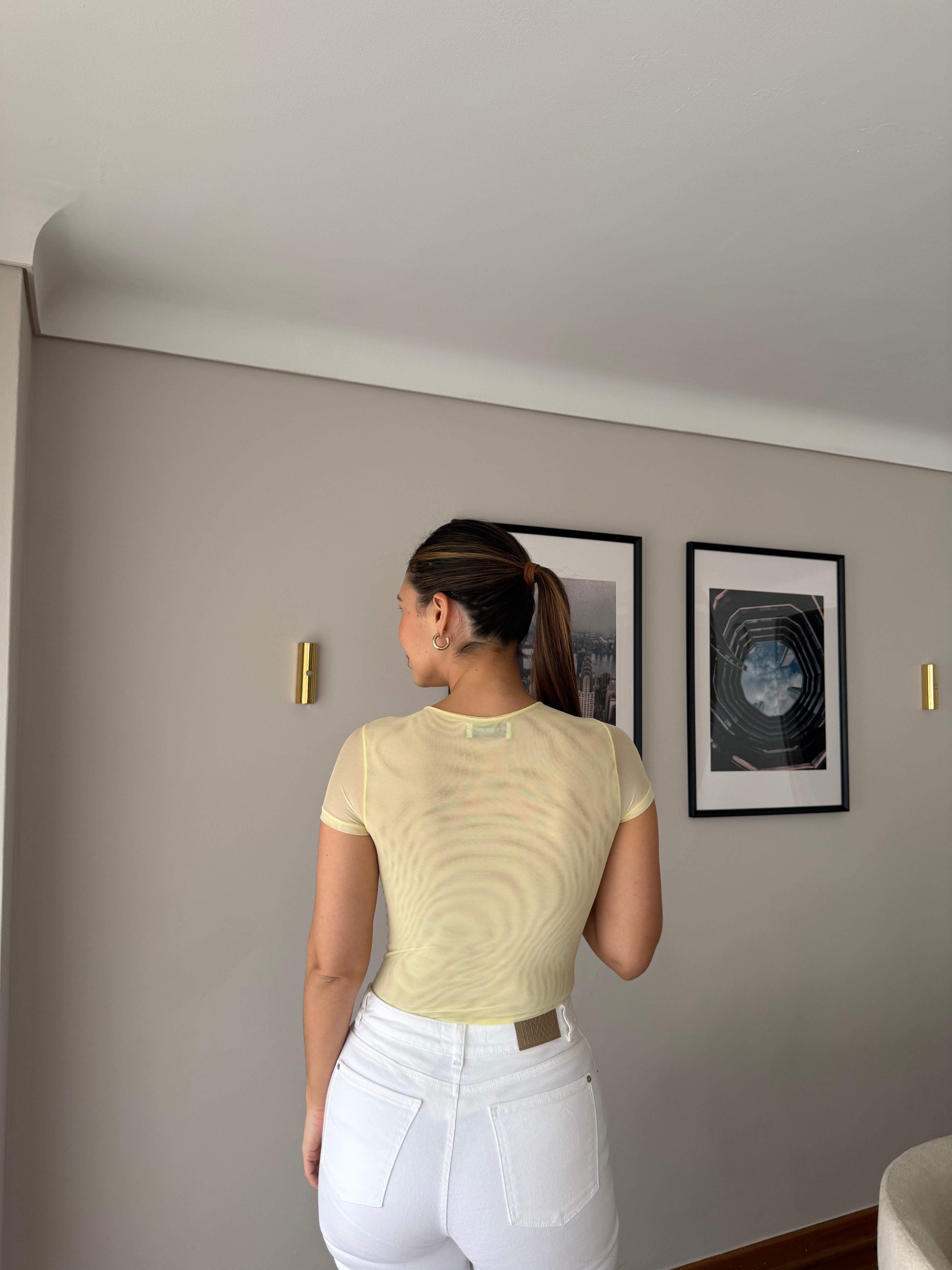Body Luciana amarillo con mangas en malla para mujer, vista trasera con jean blanco