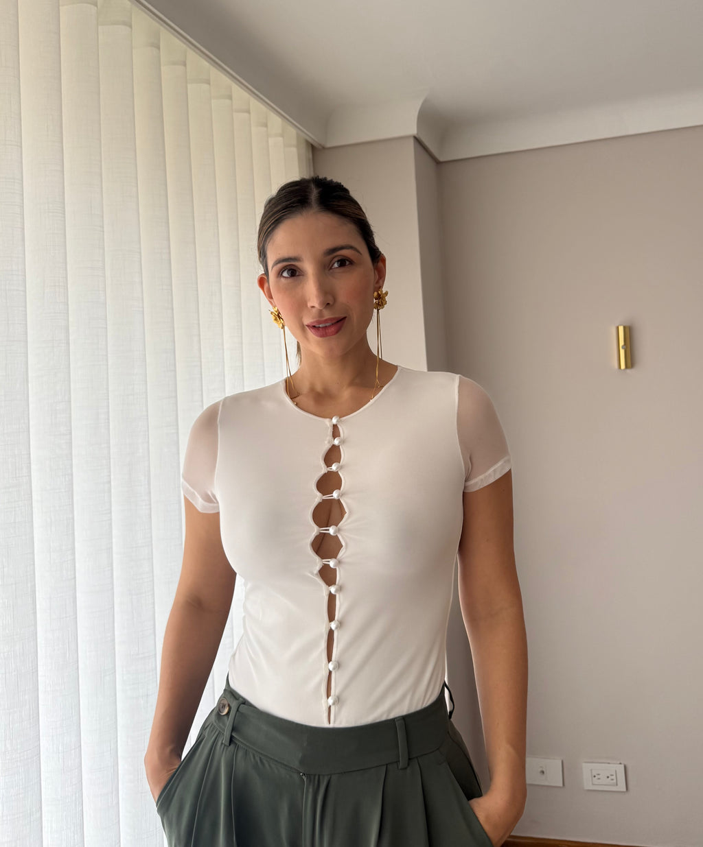 Detalle de la línea de botones al frente del body Luciana blanco para mujer con pantalón verde oliva