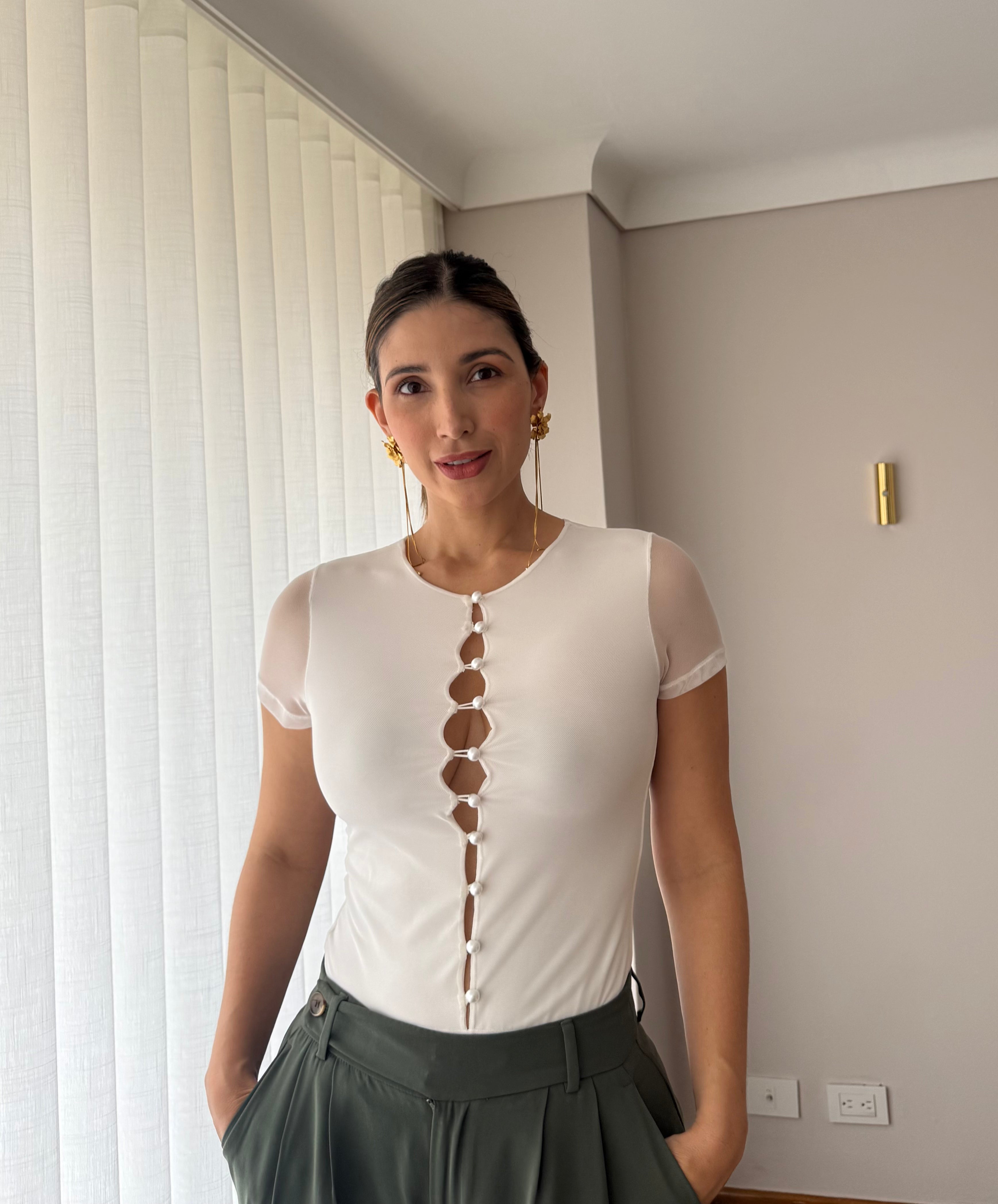 Detalle de la línea de botones al frente del body Luciana blanco para mujer con pantalón verde oliva