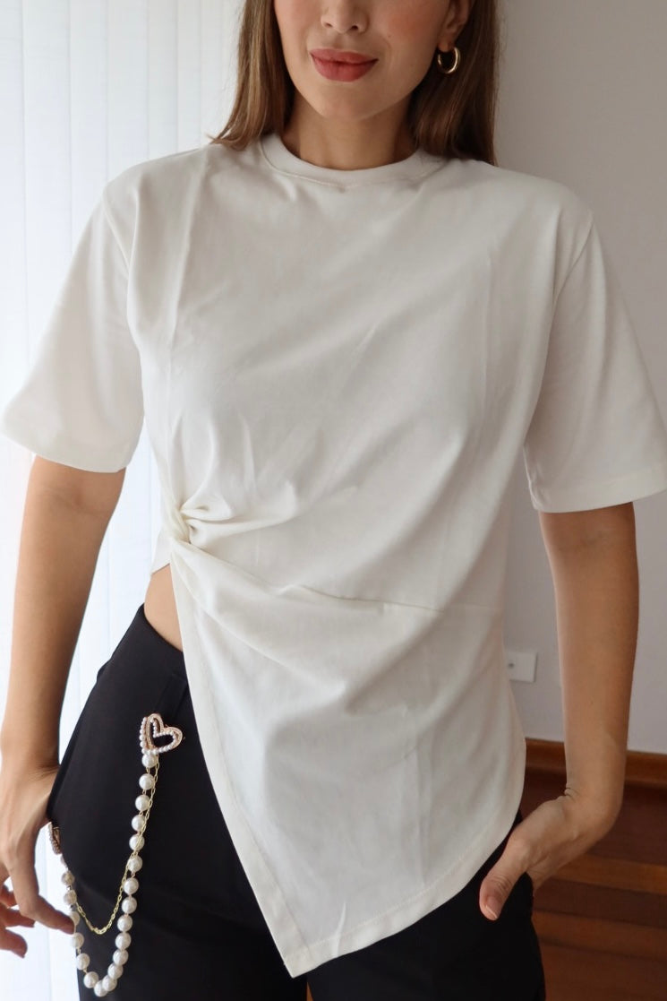 Detalle del nudo asimétrico y el dobladillo en diagonal de la camiseta Lucia blanca para mujer