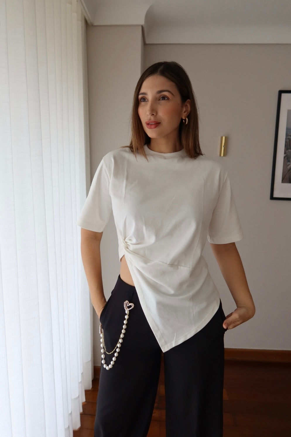 Camiseta Lucia blanca con nudo asimétrico para mujer, vista frontal con pantalón negro