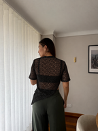 Camiseta Mila negra de encaje para mujer, vista trasera con pantalón verde oliva