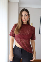 Mujer con camiseta Mila vinotinto de encaje floral y pantalón negro, vista frontal