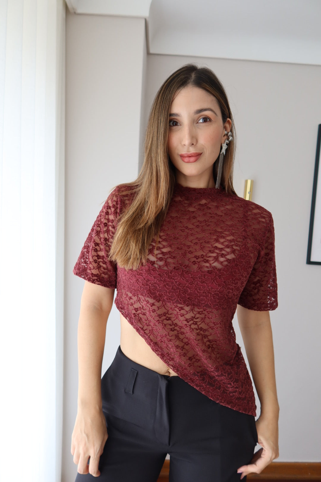 Mujer con camiseta Mila vinotinto de encaje floral y pantalón negro, vista frontal