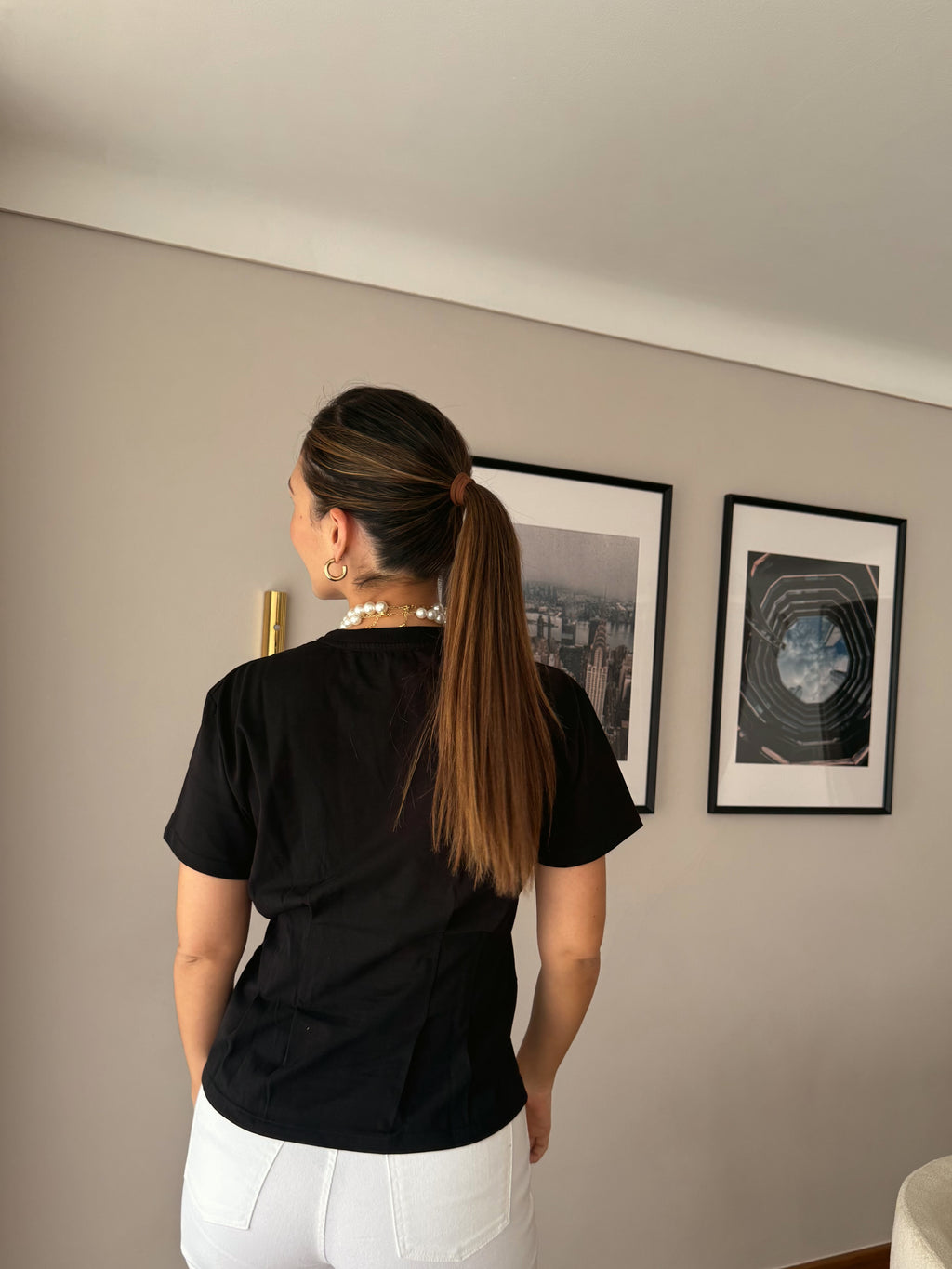 Camiseta negra Alia para mujer, vista trasera con jean blanco
